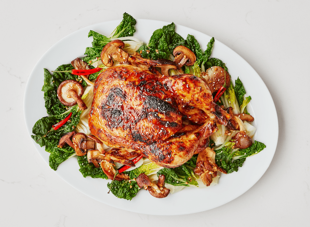 Poulet rôti entier à l'asiatique avec jeunes pak-choï et champignons